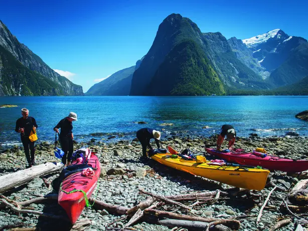 Four people preparing kayaks in Doubtful Sound