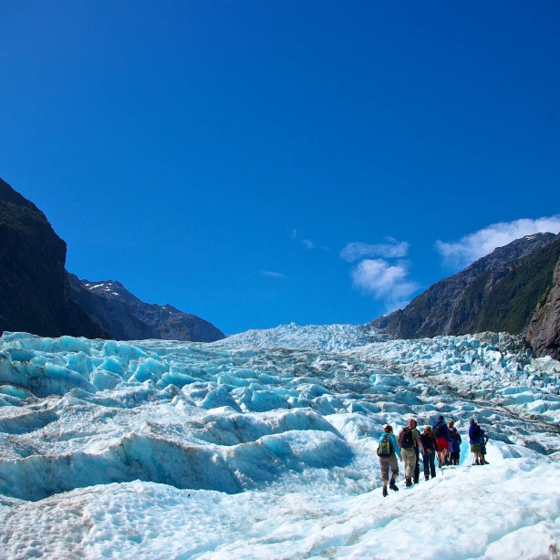 Wandelaars lopen over het blauwe ijs van Fox Glacier in Nieuw-Zeeland
