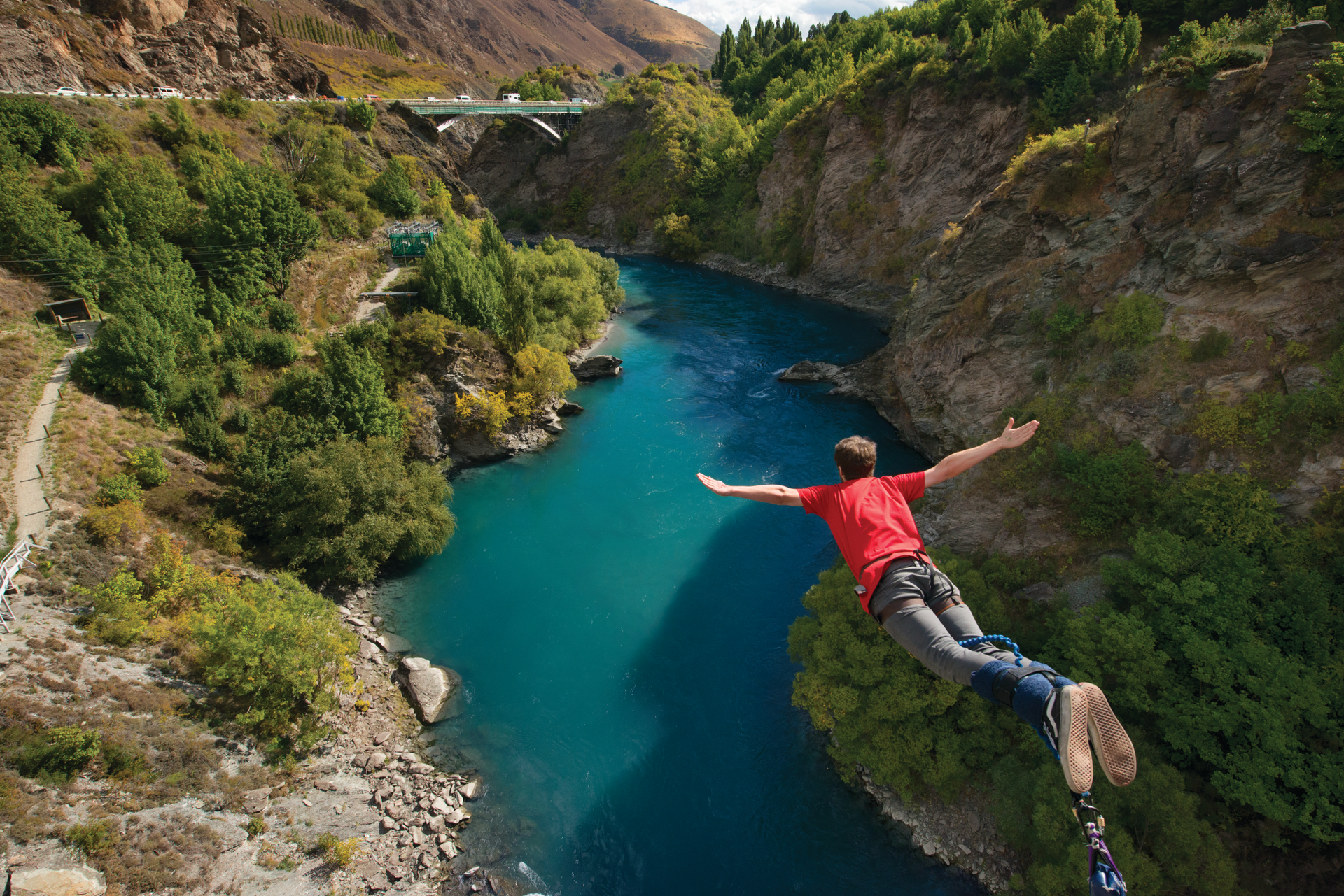 Mann beim Bungee Jumping über Fluss in Queenstown Neuseeland