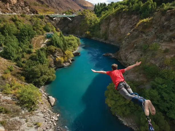 Mann beim Bungee Jumping über Fluss in Queenstown Neuseeland