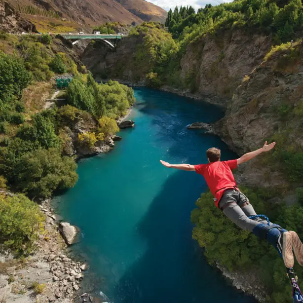 Mann beim Bungee Jumping über Fluss in Queenstown Neuseeland