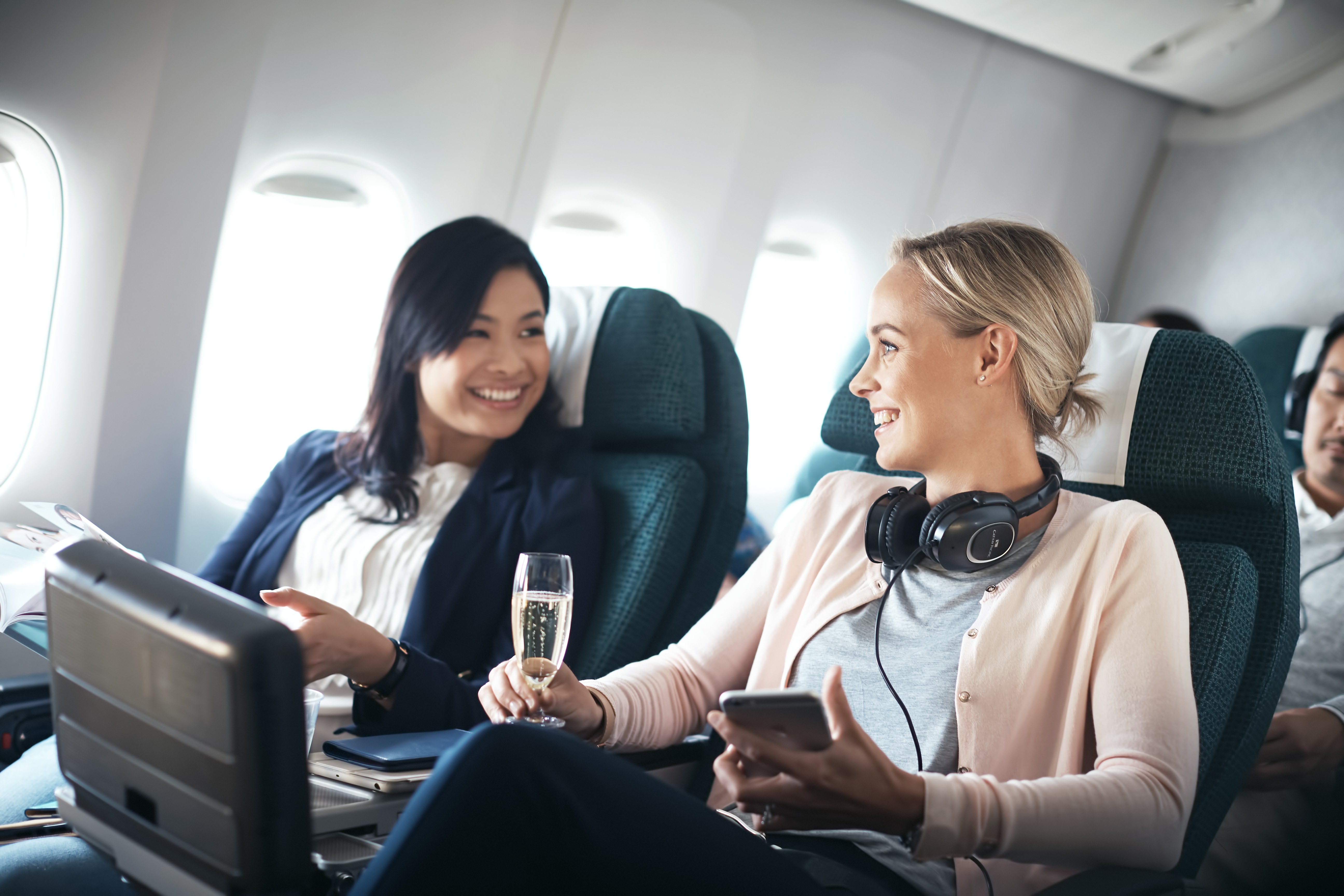 Reizigers op Premium Economy vluchten praten met een glas champagne