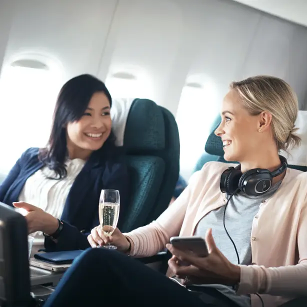Reizigers op Premium Economy vluchten praten met een glas champagne