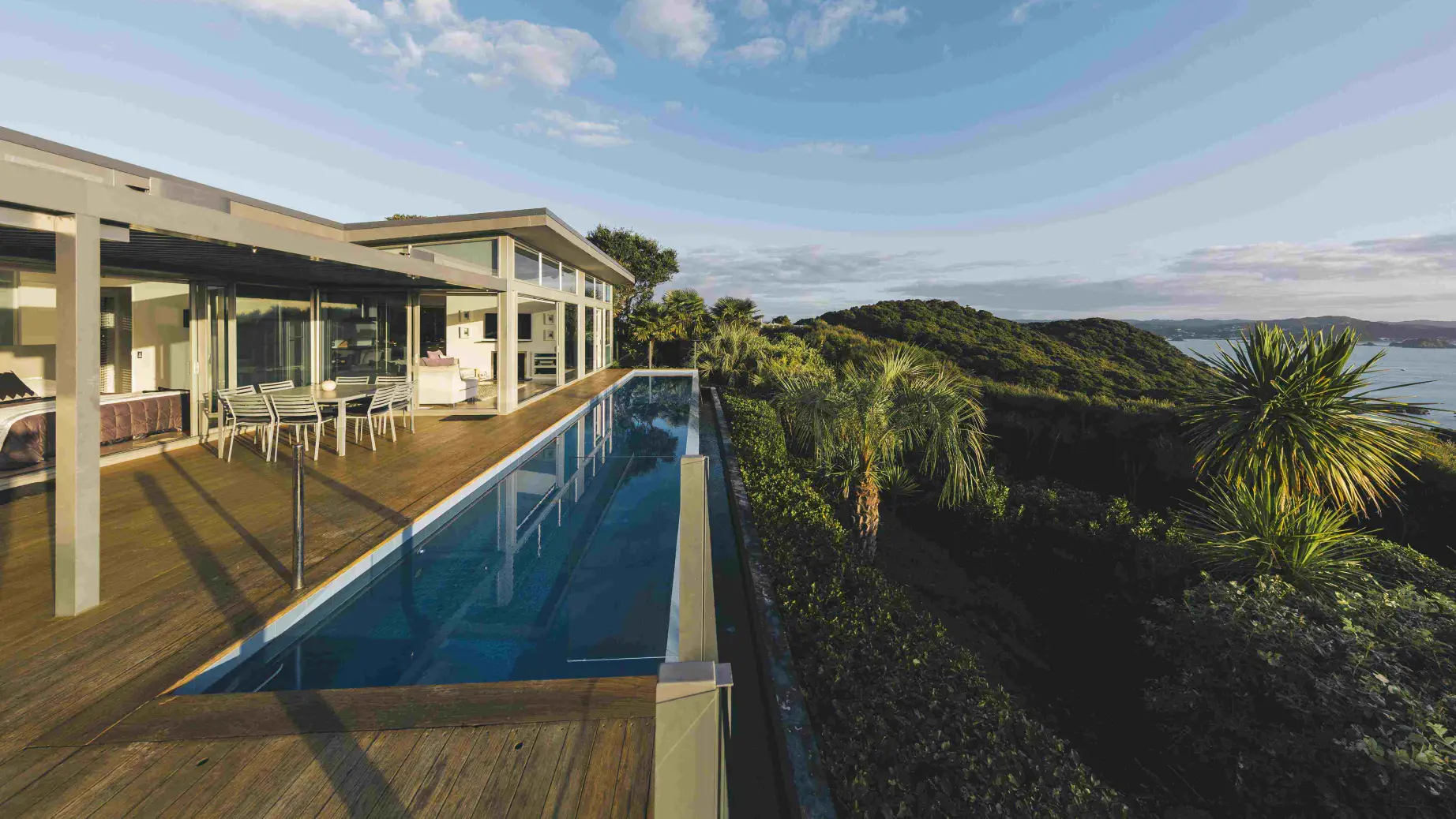 Luxuriöse Unterkunft mit Pool in Neuseeland mit Blick über Hügel und Wasser