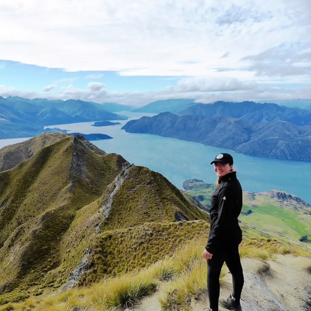 Frau steht vor Bergpanorama und See in Neuseeland