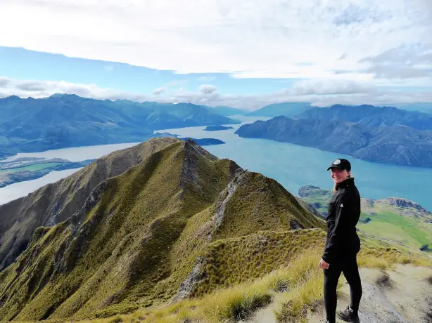 Frau steht vor Bergpanorama und See in Neuseeland