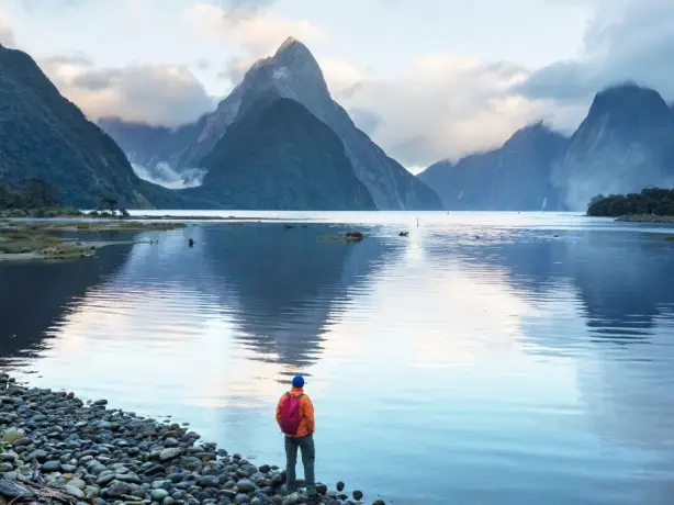 Ein Mann steht an der Küste des Milford Sound in Neuseeland