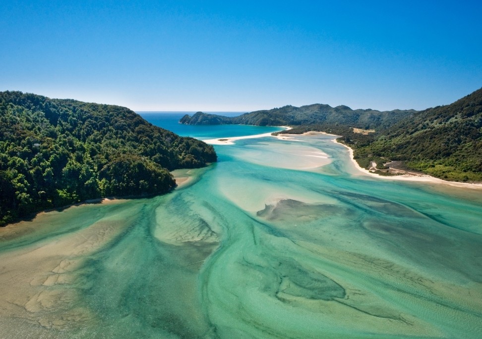 Landschapsweergave van Abel Tasman National Park, Nieuw-Zeeland, waar blauwe zeeën, gele kusten en groene bossen samenkomen