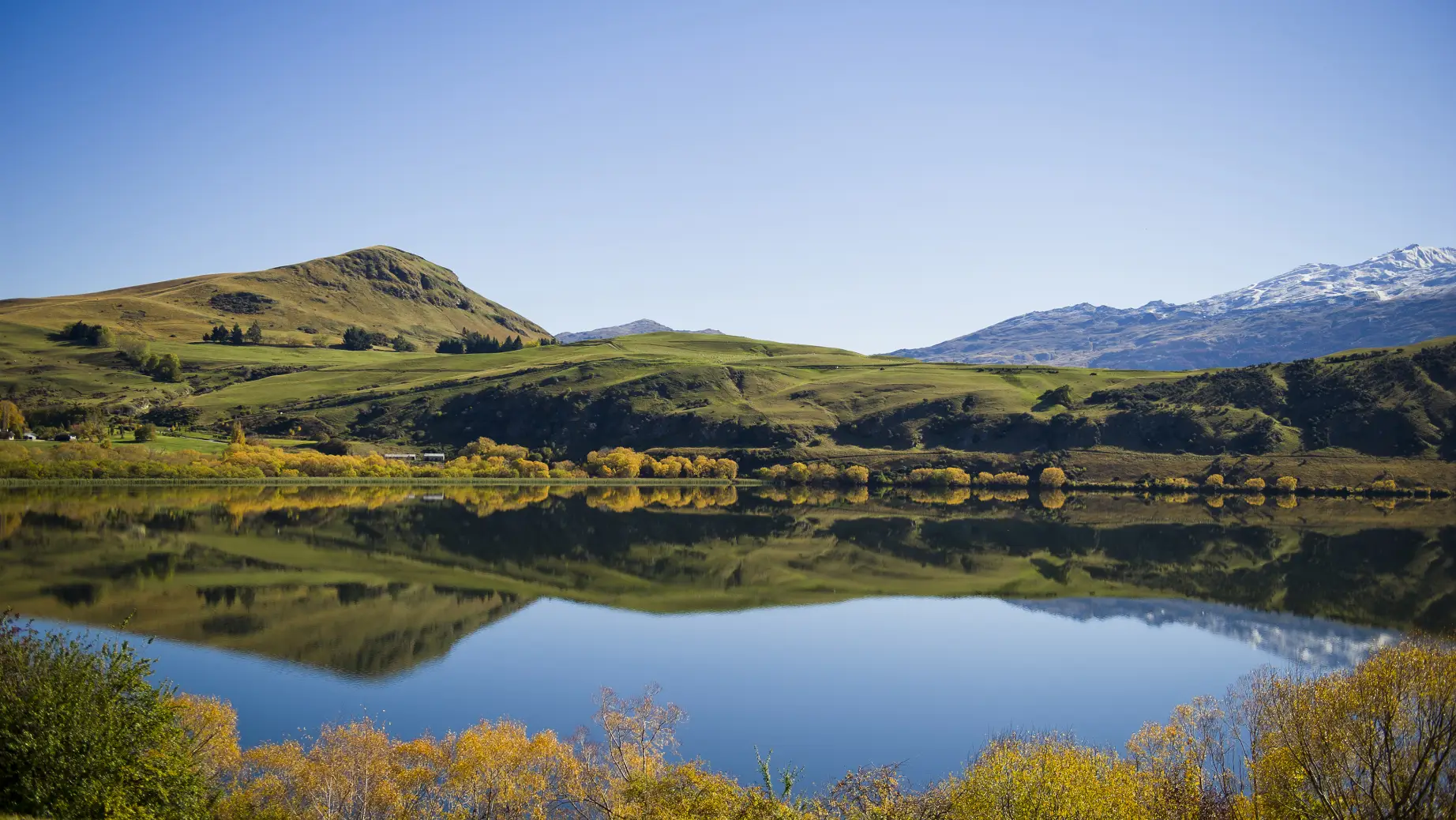 Malerischer Blick über den Haynes Lake mit einer Bergkette im Hintergrund nahe Queenstown