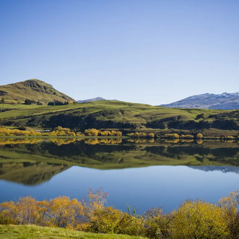Malerischer Blick über den Haynes Lake mit einer Bergkette im Hintergrund nahe Queenstown