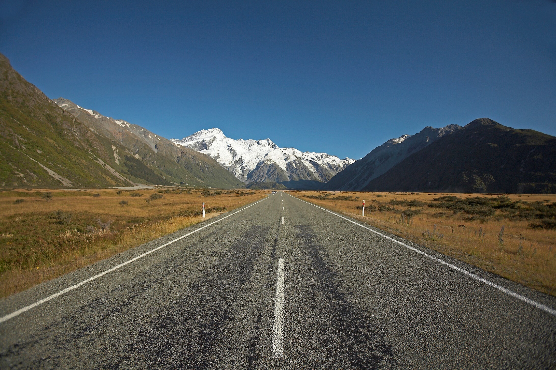 Mount Cook Road omringd door velden en bergen in Nieuw-Zeeland