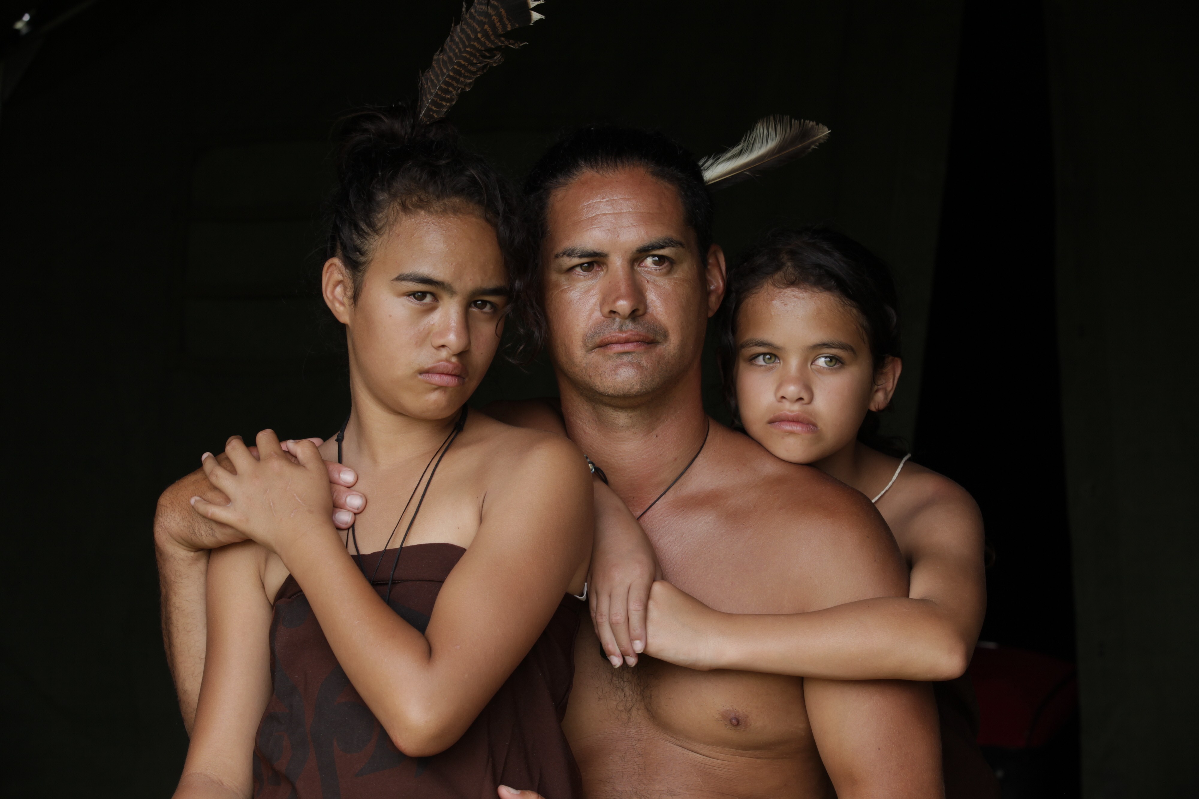 Porträt einer Māori-Familie mit einem Mann und zwei jungen Mädchen