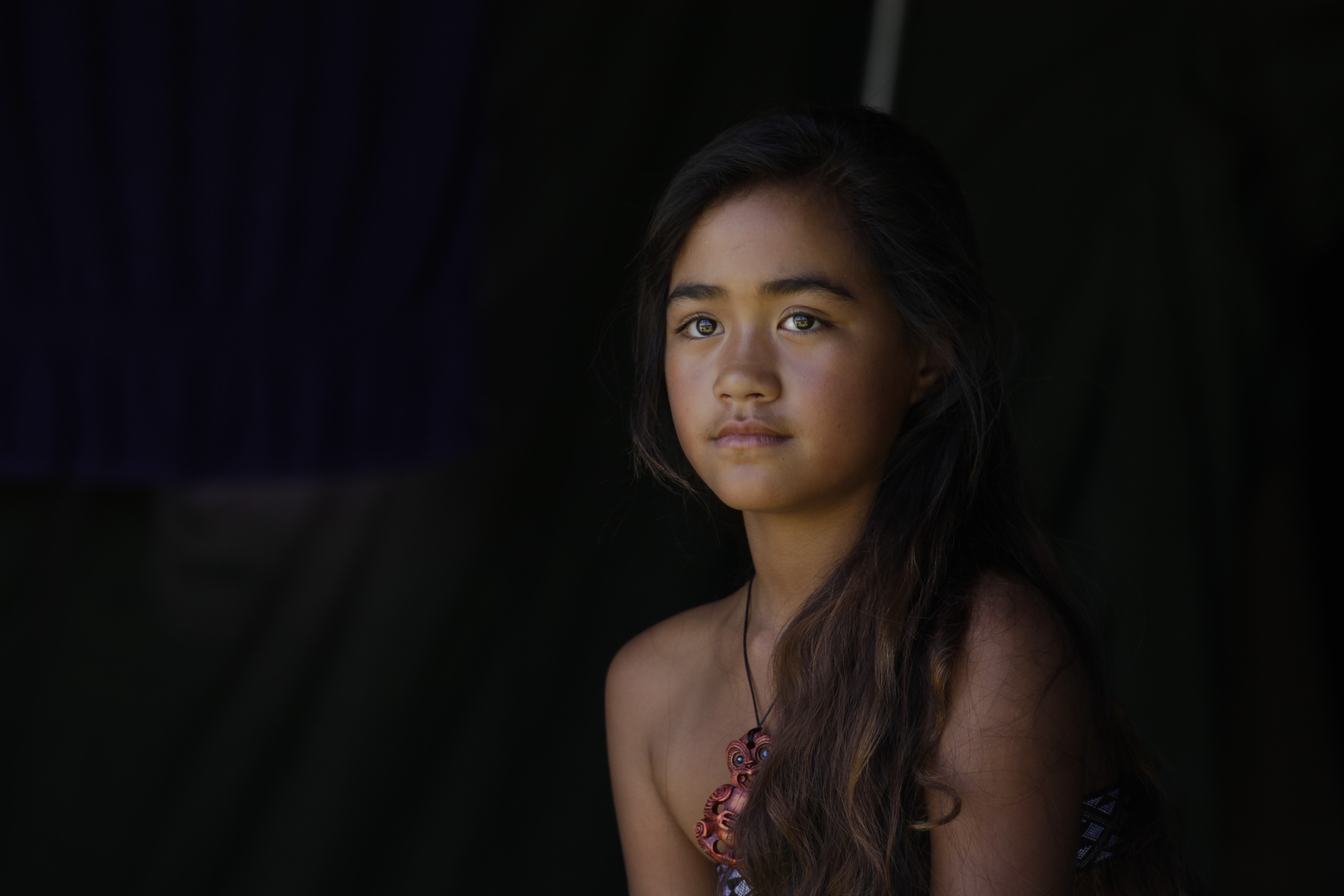 Neuseeländisches Māori-Mädchen mit einer Halskette und langem schwarzen Haar