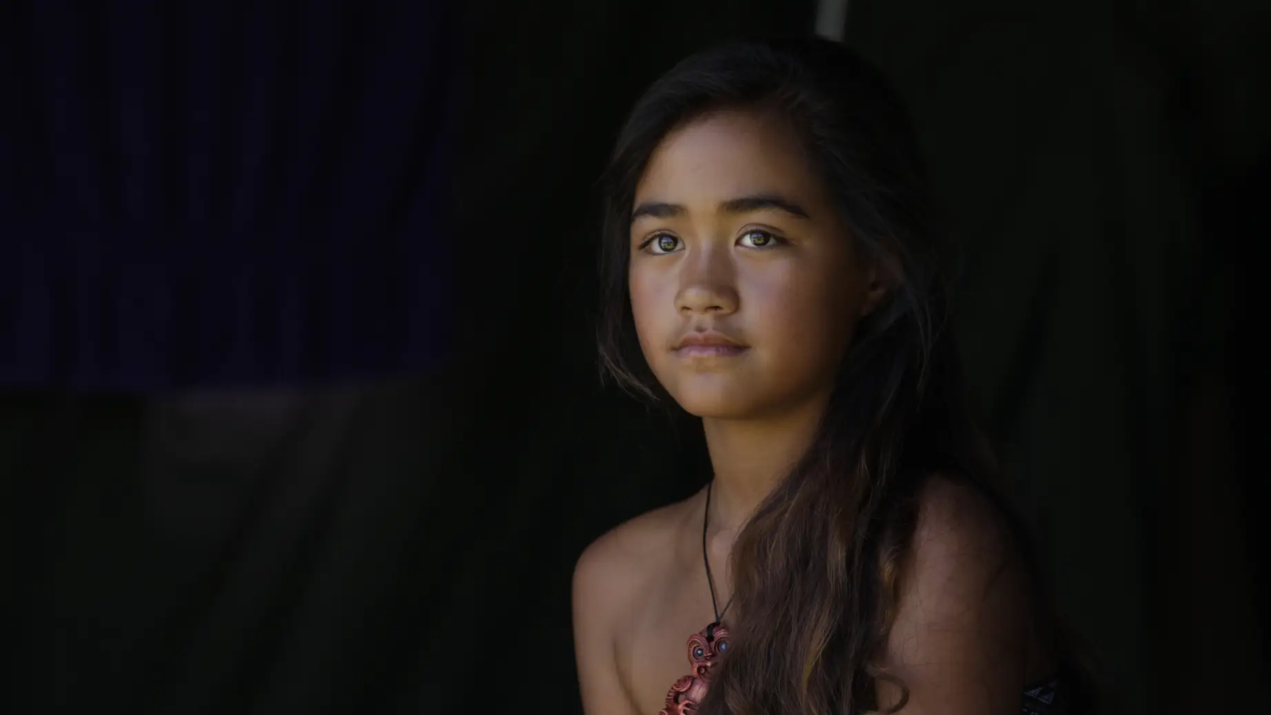 Neuseeländisches Māori-Mädchen mit einer Halskette und langem schwarzen Haar