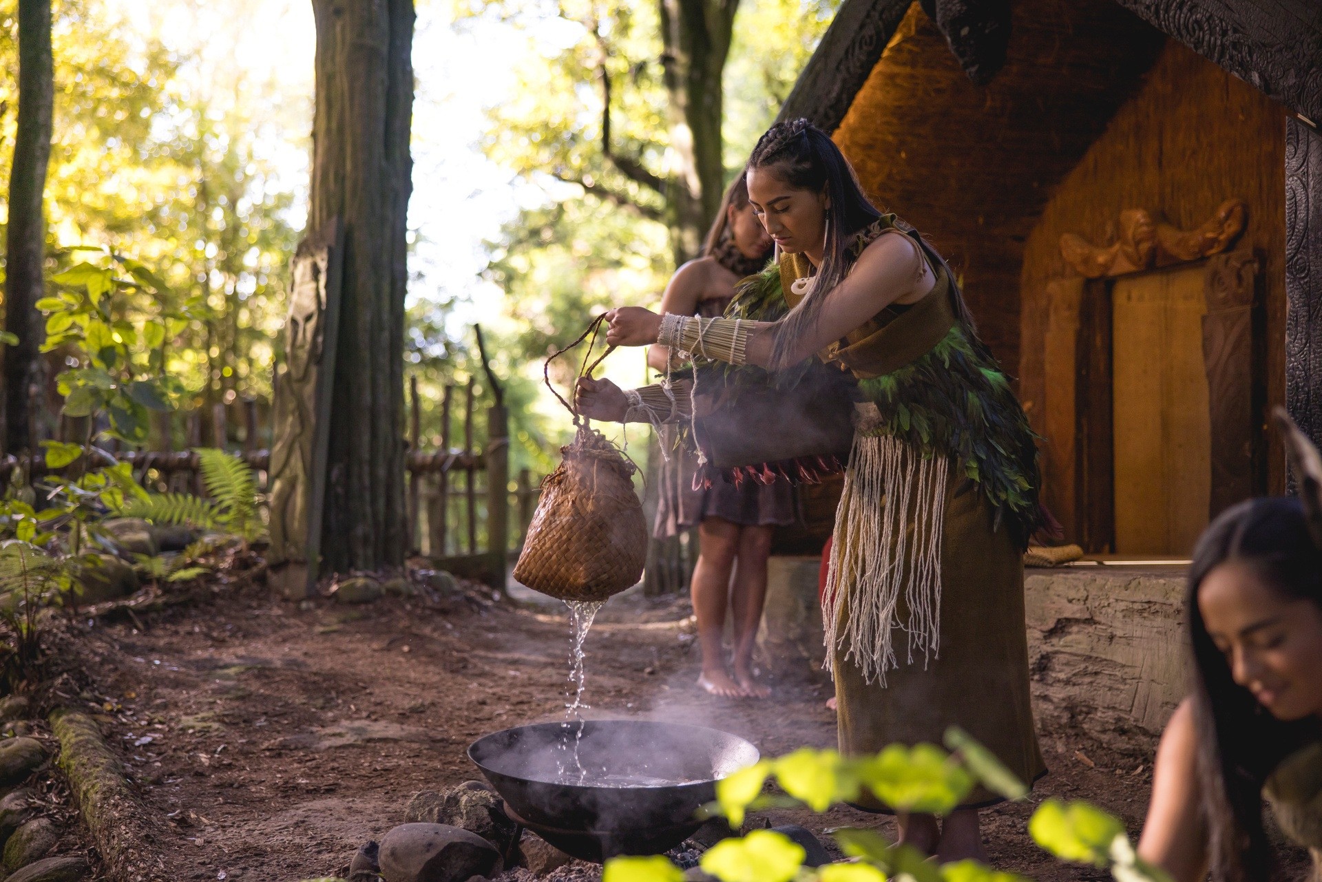 Frau in traditioneller Maori Kleidung folgt einem Ritual in Rotorua