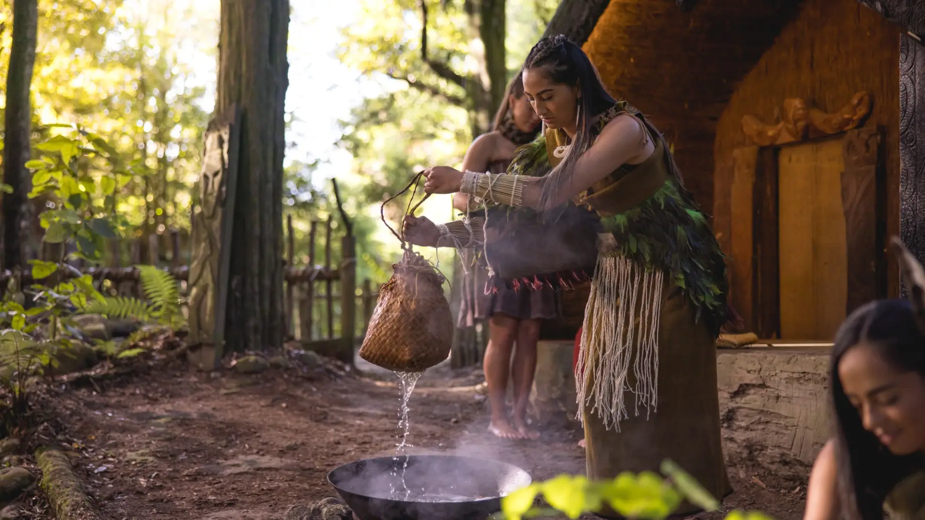 Frau in traditioneller Maori Kleidung folgt einem Ritual in Rotorua