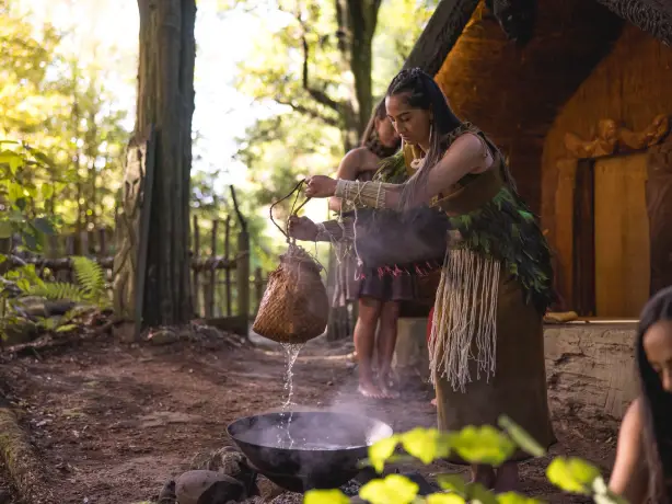 Frau in traditioneller Maori Kleidung folgt einem Ritual in Rotorua