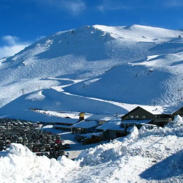 Skigebiet mit schneebedeckten Bergen und Häusern in Neuseeland