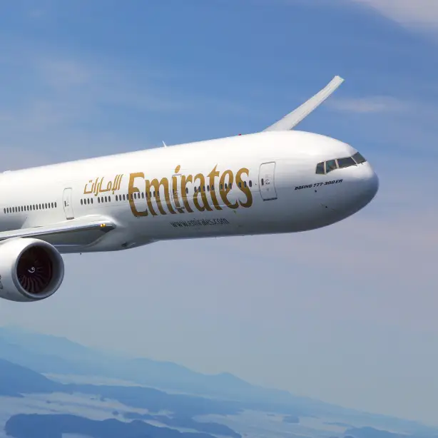 Emirates plane flying against a blue sky