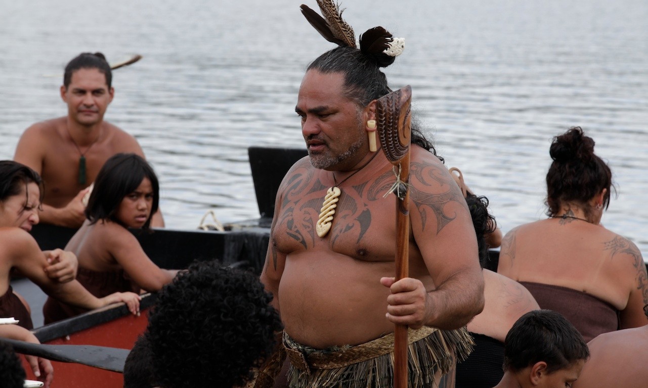 Een groep Māori in een boot met een man op de voorgrond