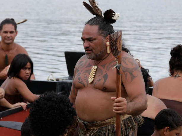 Een groep Māori in een boot met een man op de voorgrond