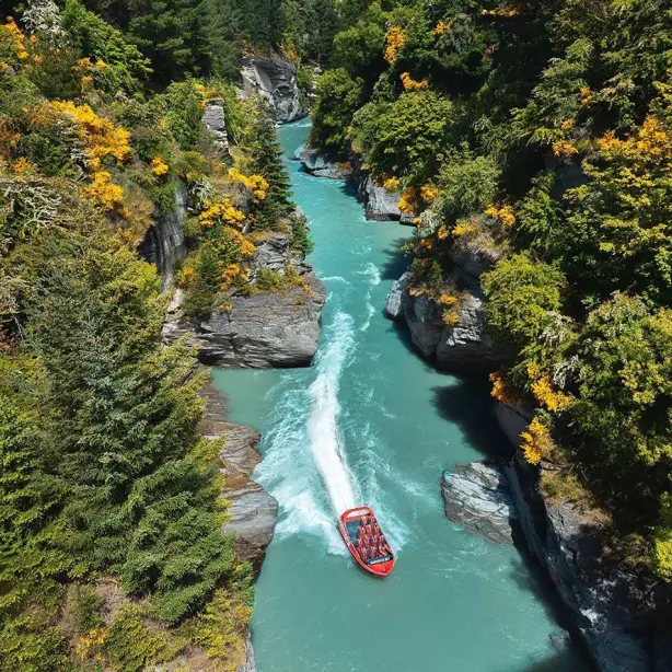 A boat moving along a river between rocky and forest terrain in New Zealand