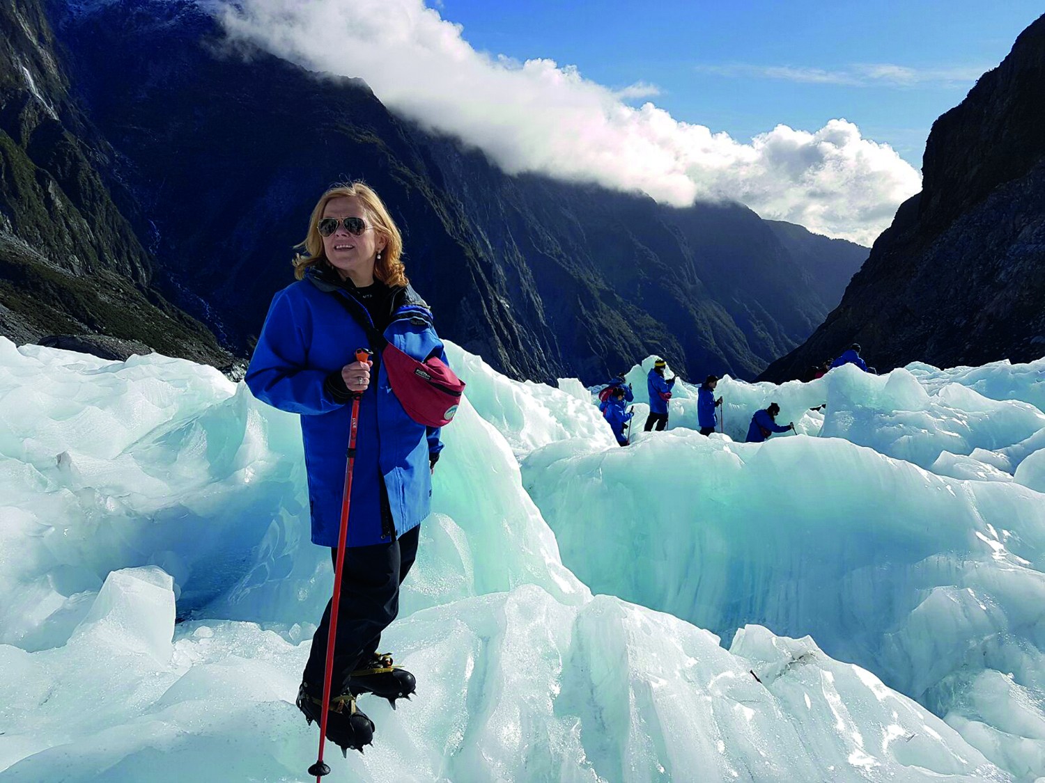 Woman hiking on Fox glacier with other hikers in the background