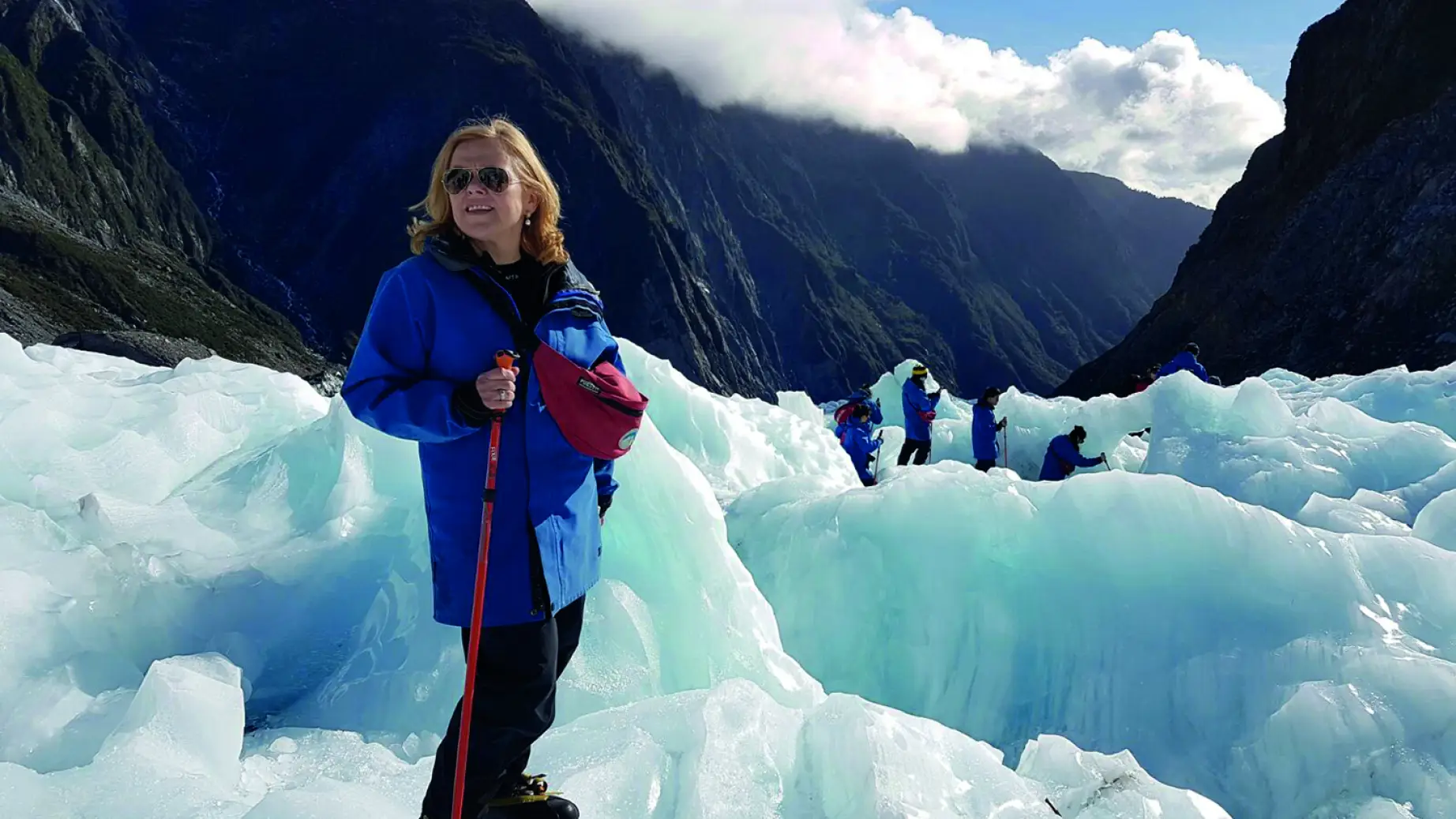 Woman hiking on Fox glacier with other hikers in the background