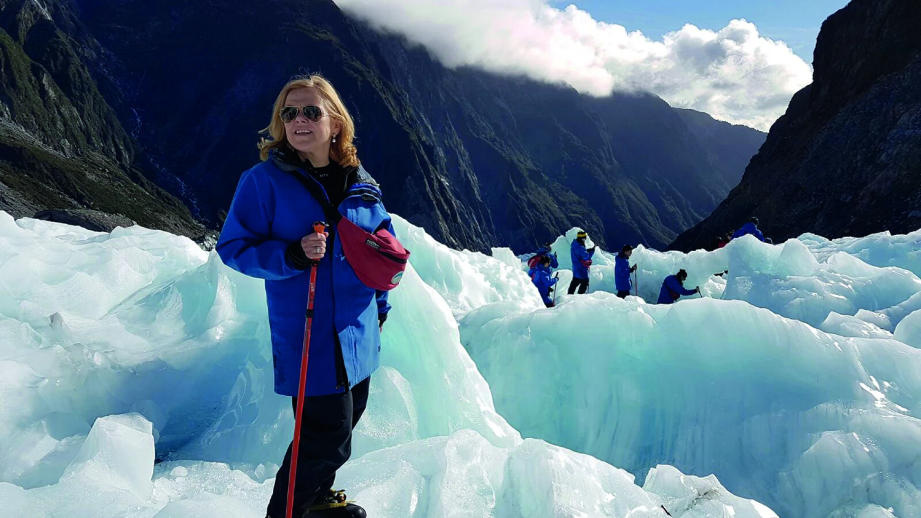 Woman hiking on Fox glacier with other hikers in the background