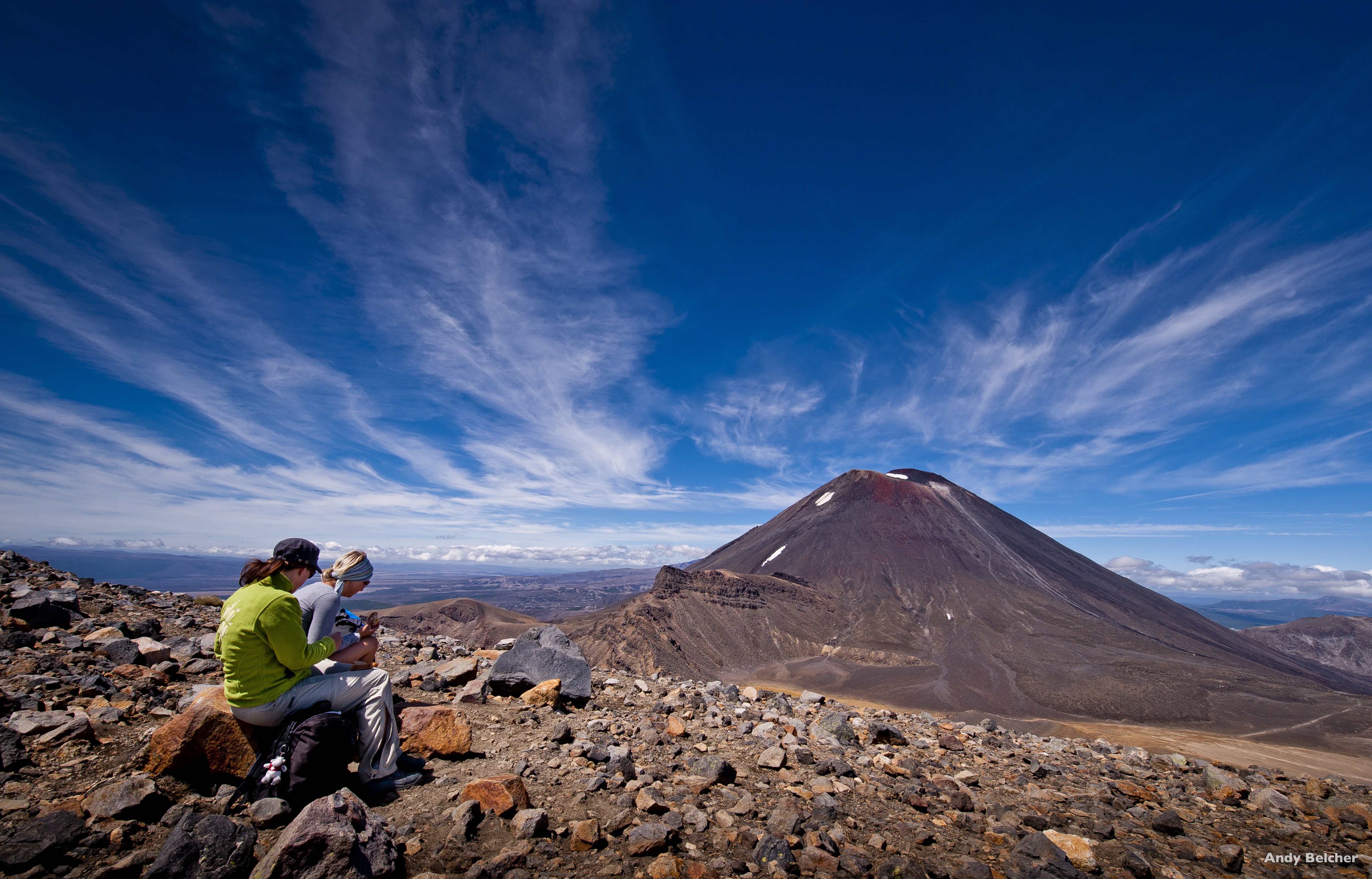 Zwei Frauen sitzen auf einem Felsen beim Tongariro Alpine Crossing in Neuseeland