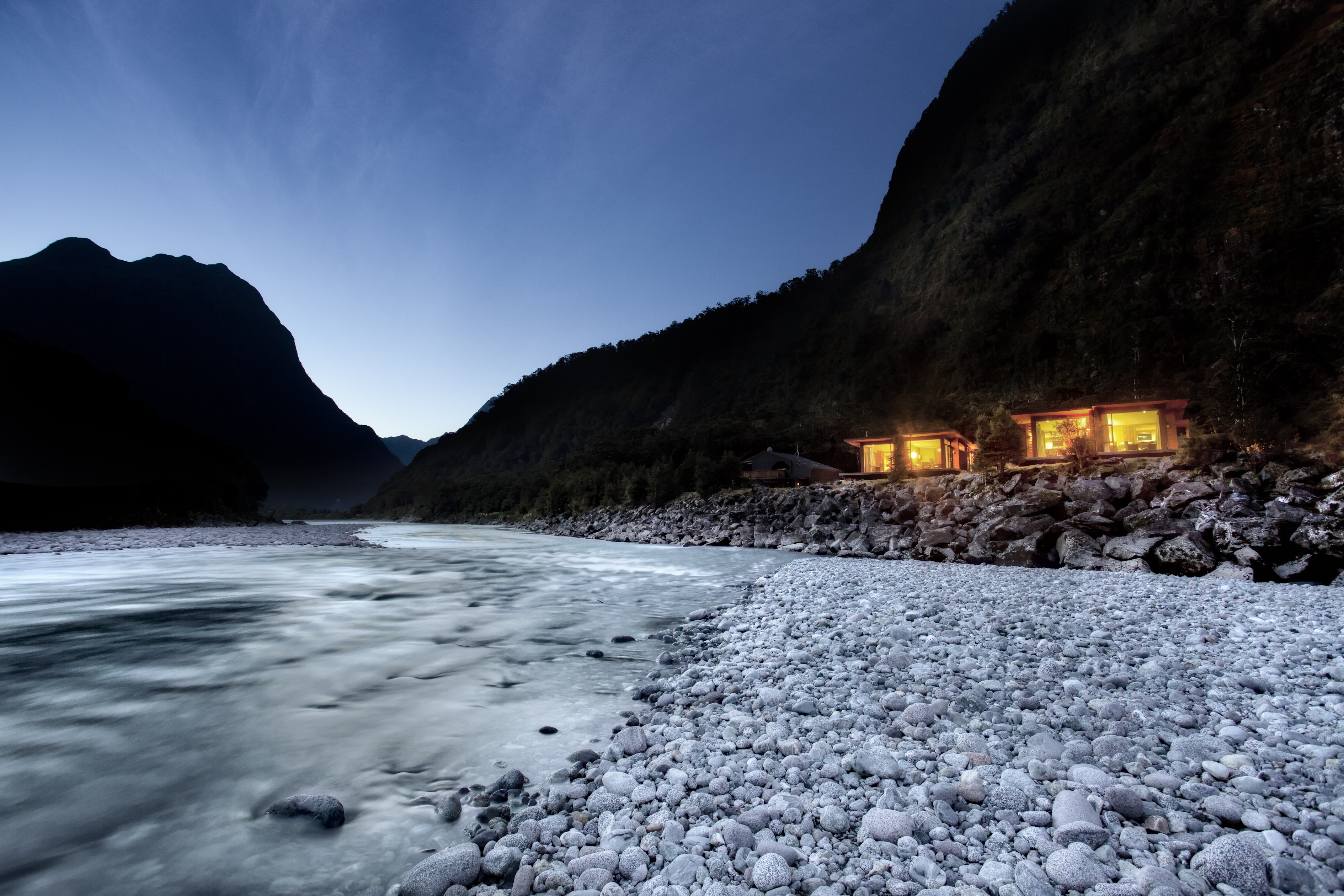 Ein Chalet liegt am Fluss im Milford Sound, Fiordland National Park, Neuseeland