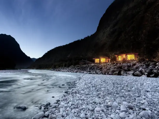 Ein Chalet liegt am Fluss im Milford Sound, Fiordland National Park, Neuseeland