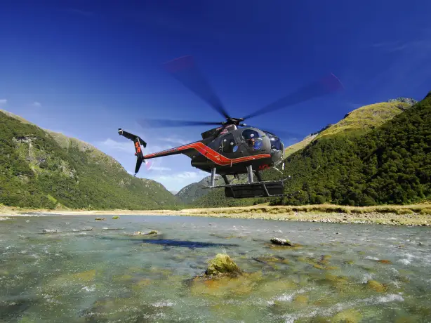 Helikopter schwebt über Gewässer vom Mount Aspiring National Park