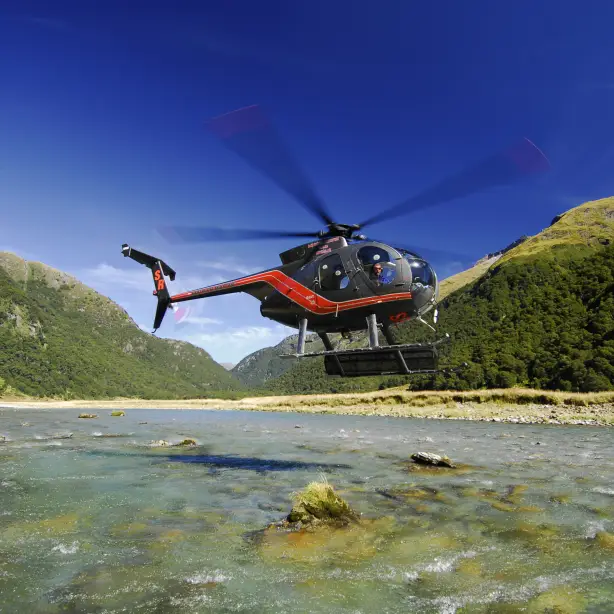 Helikopter schwebt über Gewässer vom Mount Aspiring National Park