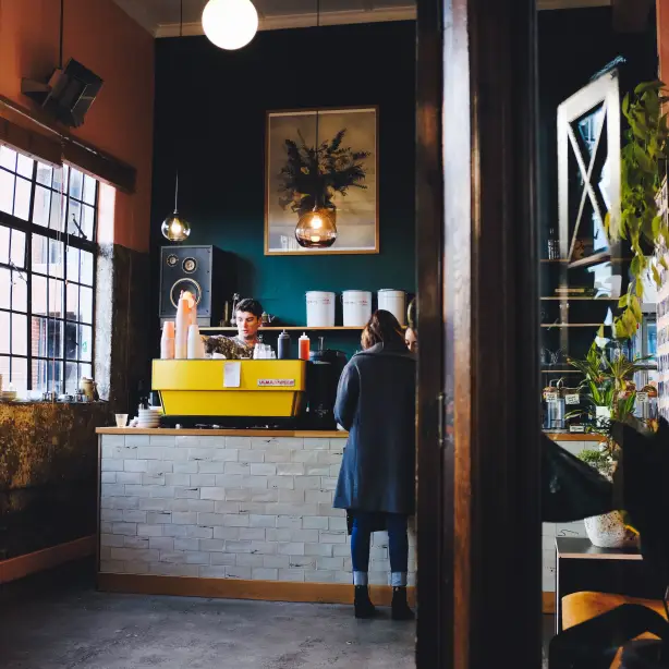 Personen stehen an Schalter in cafe in Neuseeland