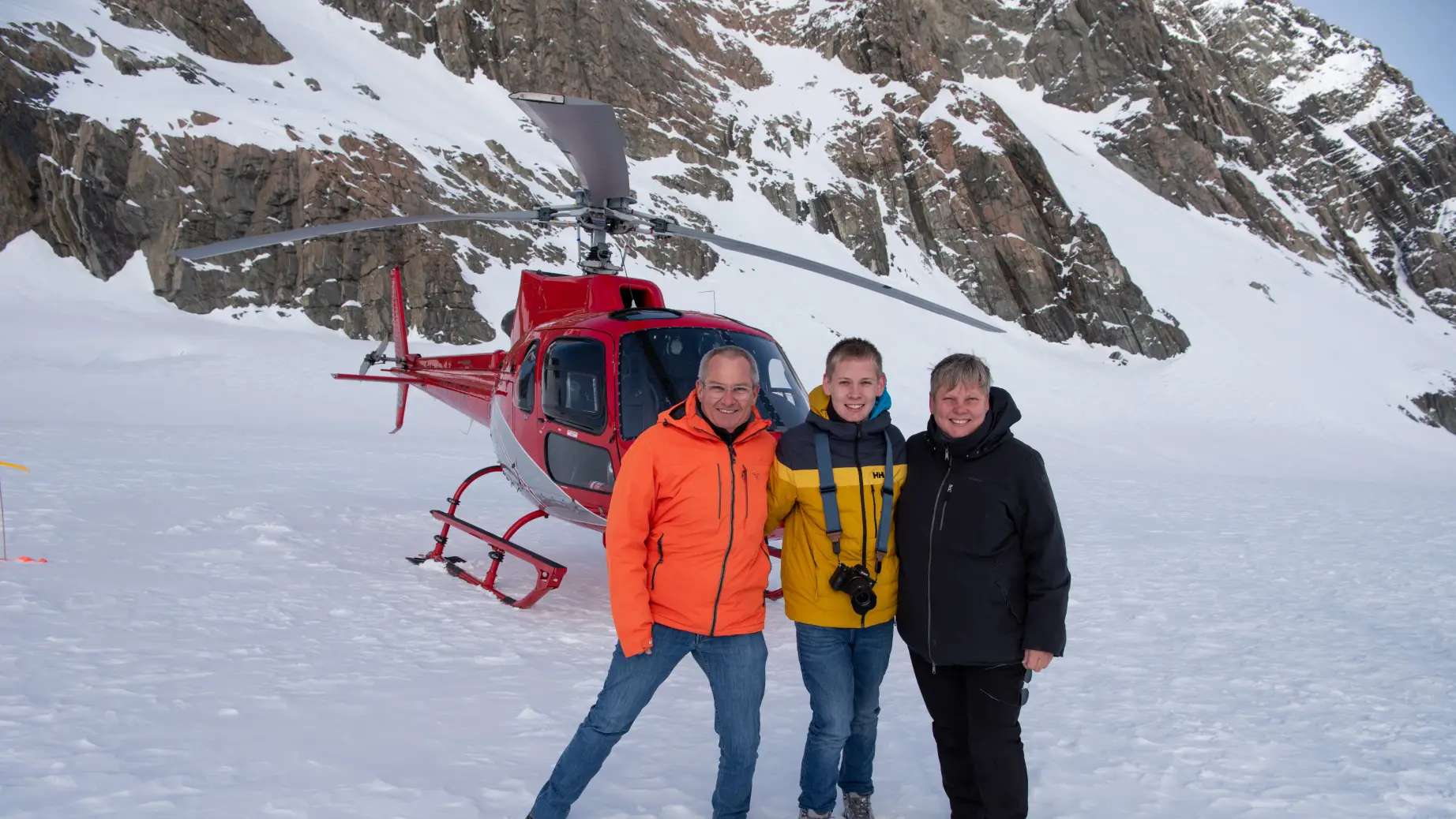 Die Familie Linke posiert vor einem Hubschrauber im Schnee