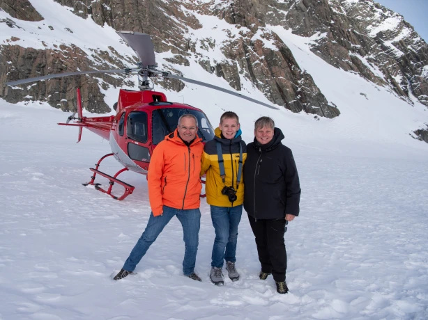 De familie Linke poseert voor een helikopter in de sneeuw