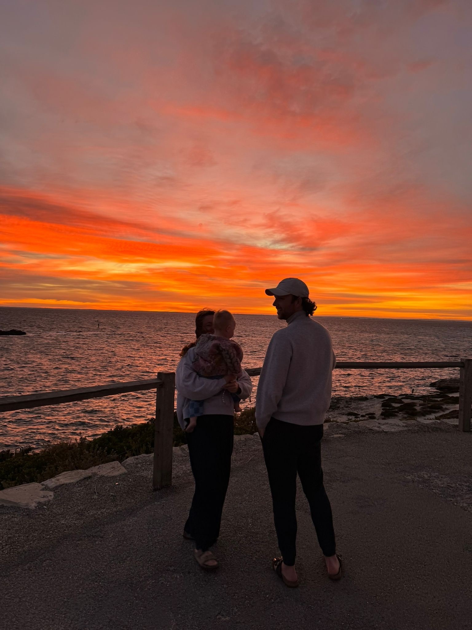 Jong gezin aan zee tijdens zonsondergang