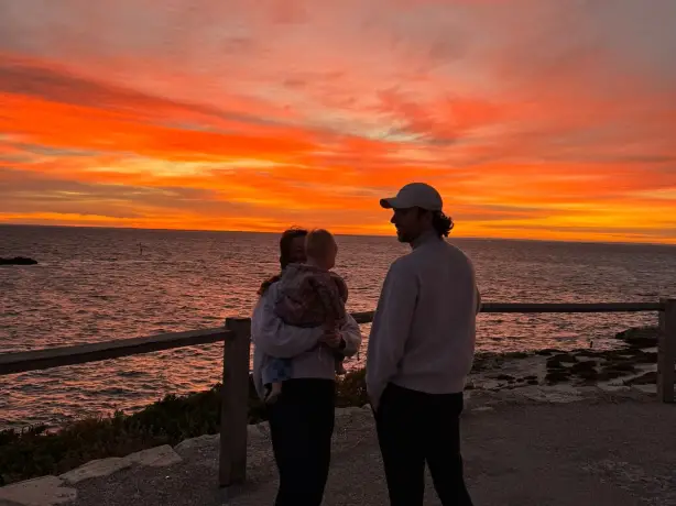 Jong gezin aan zee tijdens zonsondergang