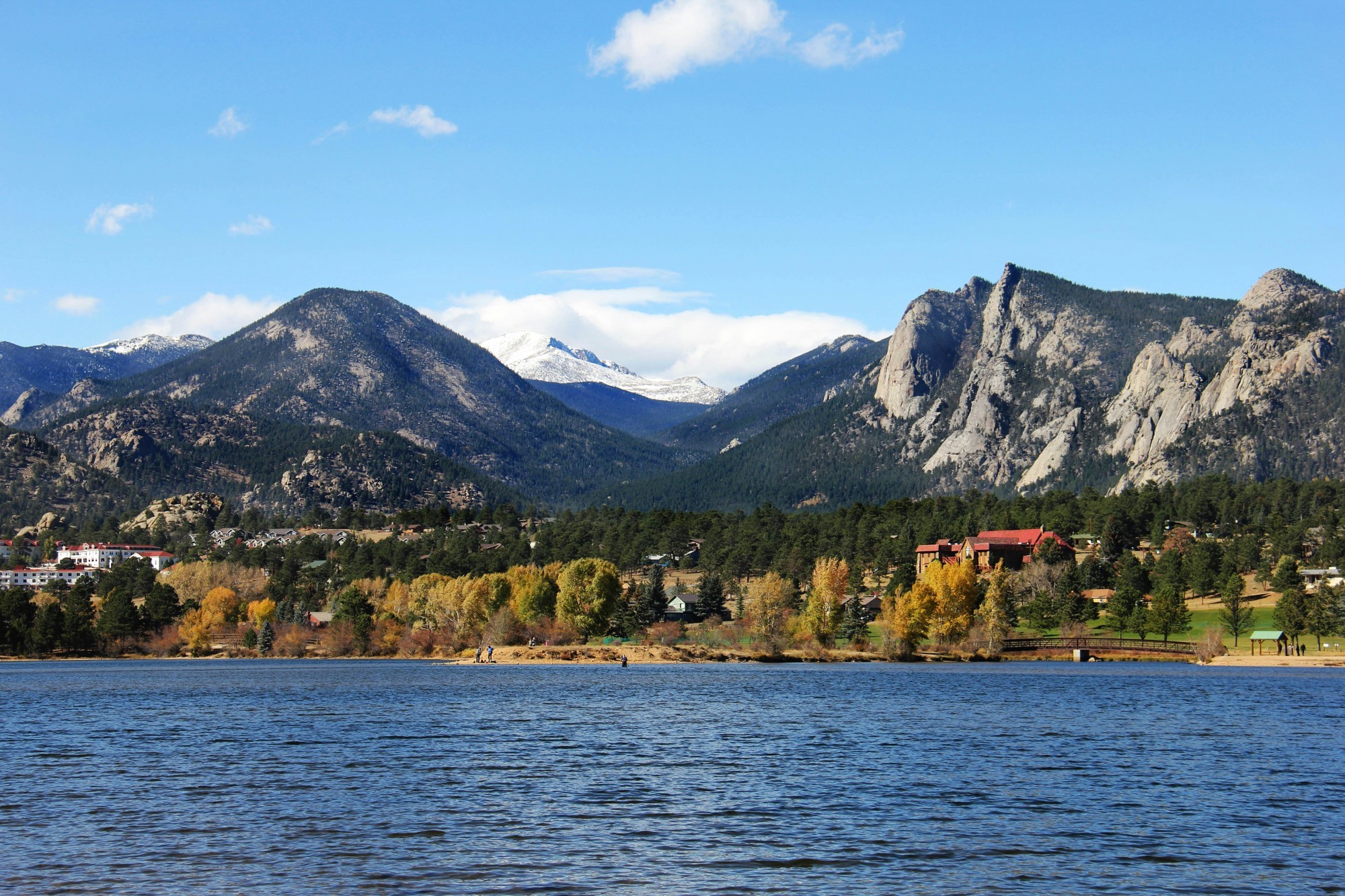 Ruhiger See mit Bergpanorama im Hintergrund und herbstlicher Wald in Estes Park, Colorado