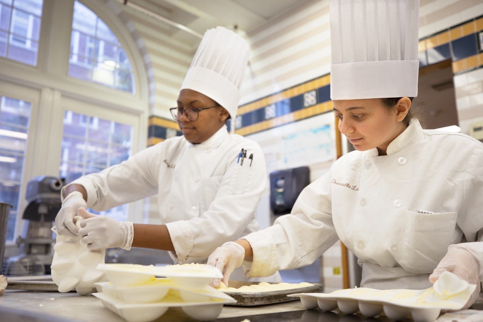 Zwei weibliche Kochstudenten bereiten Essen zu in den USA