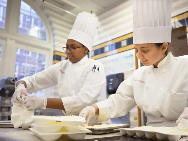 Zwei weibliche Kochstudenten bereiten Essen zu in den USA