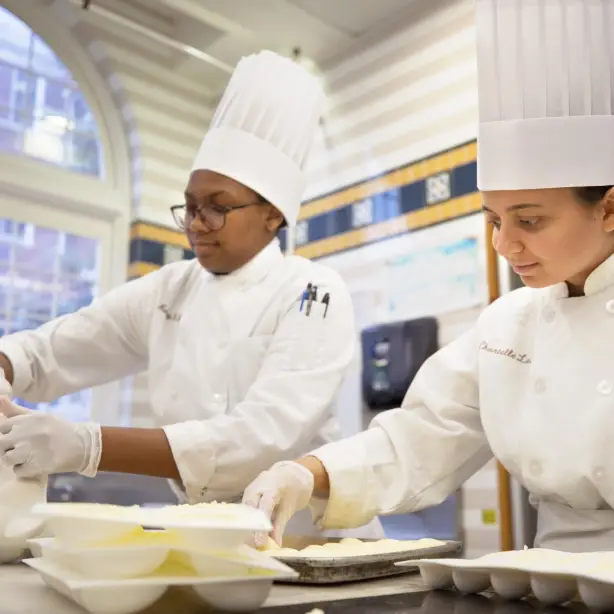 Zwei weibliche Kochstudenten bereiten Essen zu in den USA