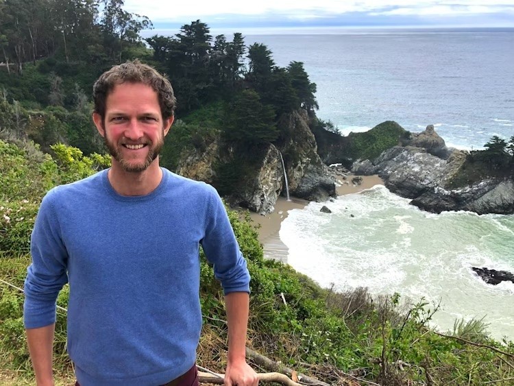 Mann steht vor Bucht mit Wasserfall in den USA