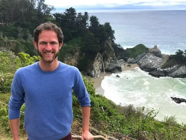 Mann steht vor Bucht mit Wasserfall in den USA
