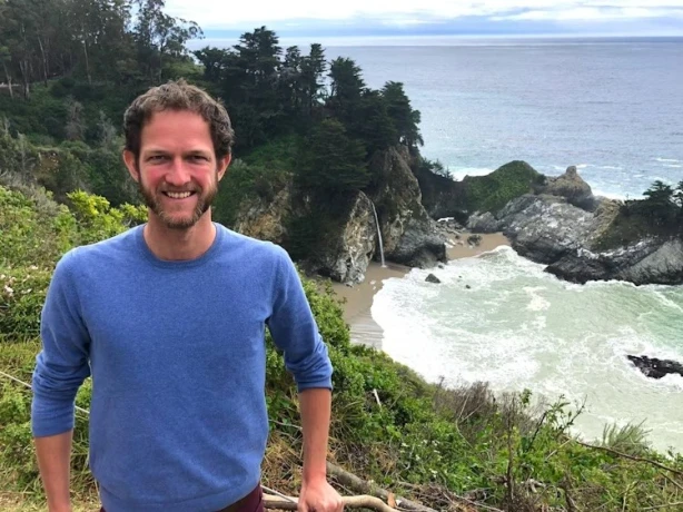 Mann steht vor Bucht mit Wasserfall in den USA