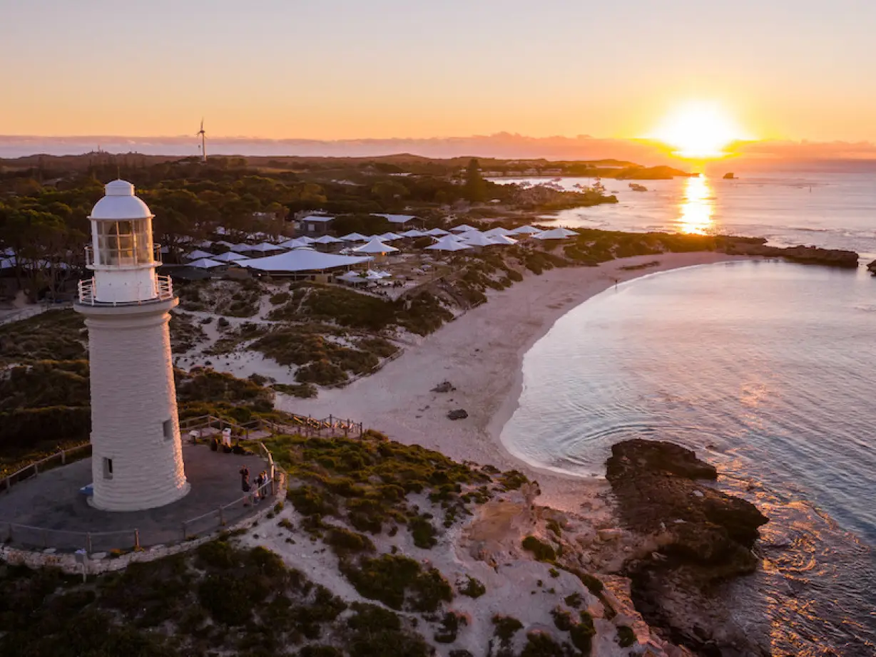 Ein Leuchtturm an der Küste mit einem Sonnenuntergang im Hintergrund